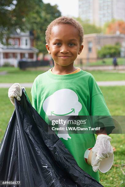 boy picking up garbage in park - kids with cleaning rubber gloves stock-fotos und bilder