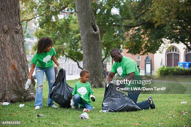 family picking up garbage in park - city cleaning 個照片及圖片檔