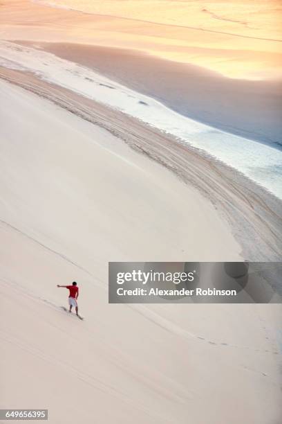 man surfing on sand dunes on beach - jericoacoara ストックフォトと画像
