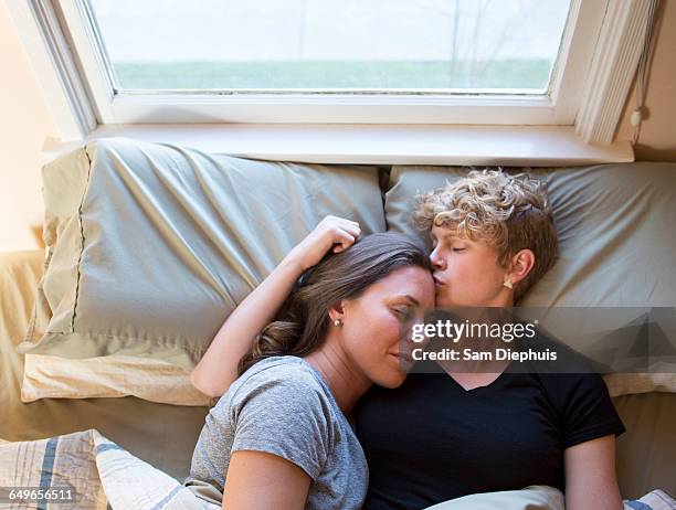 caucasian lesbian couple kissing in bed - lesbian bed stock pictures, royalty-free photos & images