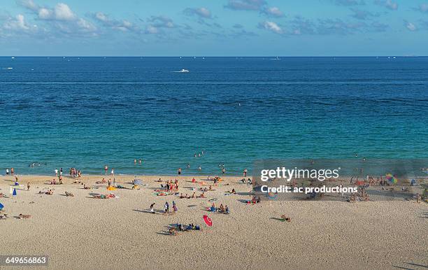 tourists sunbathing on beach - spring break stock-fotos und bilder