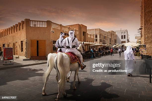 men riding horses on doha street, doha, qatar - tour of qatar fotografías e imágenes de stock