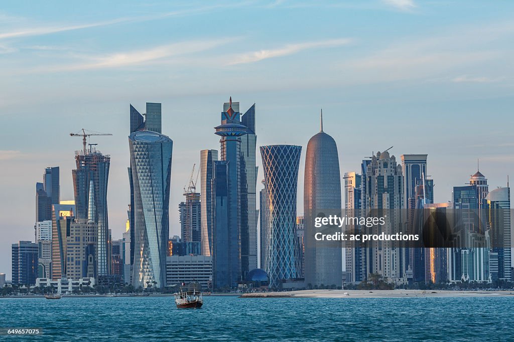 Boat floating near Doha skyline, Doha, Qatar