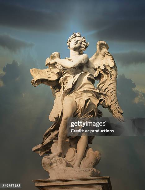 low angle view of statue under cloudy sky - fiktionale figur stock-fotos und bilder