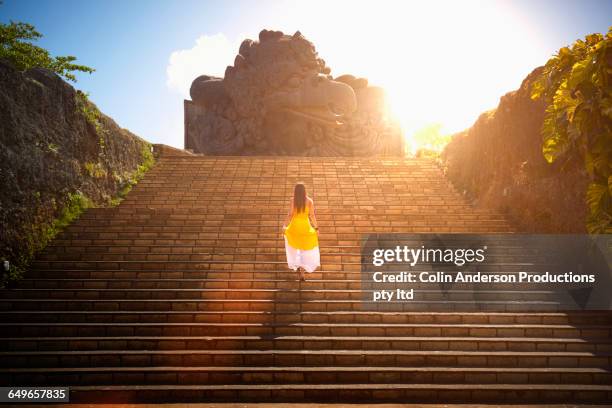 pacific islander woman walking on monument steps - kuta stock-fotos und bilder