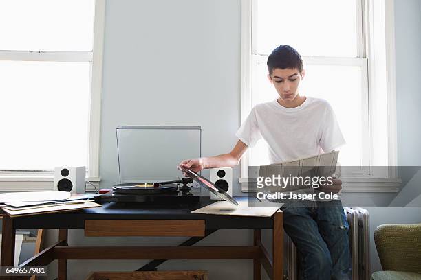 mixed race teenage boy listening to records - etereo stock pictures, royalty-free photos & images