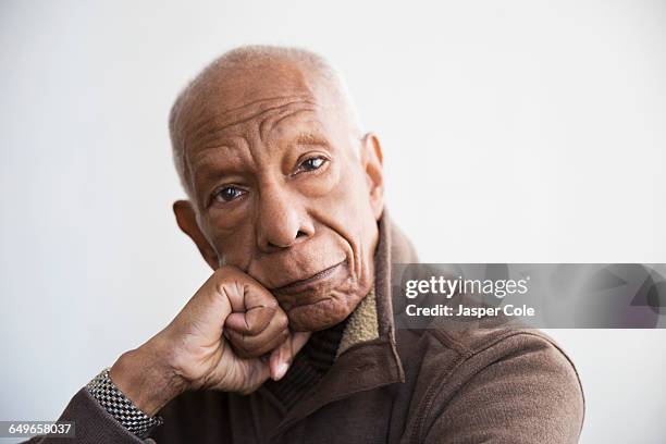 older black man resting chin in hand - african american senior man stock pictures, royalty-free photos & images