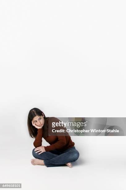 woman pouting with chin in hand - hand on chin stock pictures, royalty-free photos & images