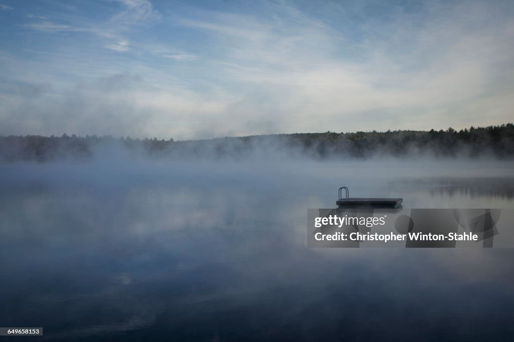 Dock floating on misty remote lake