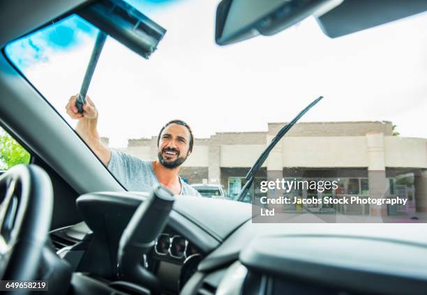 hispanic man washing windshield at gas station - clean car interior stock pictures, royalty-free photos & images