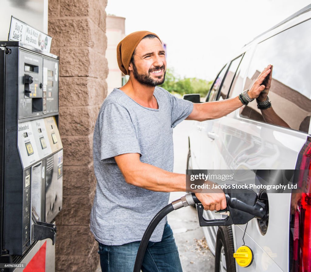 Hispanic man pumping gas