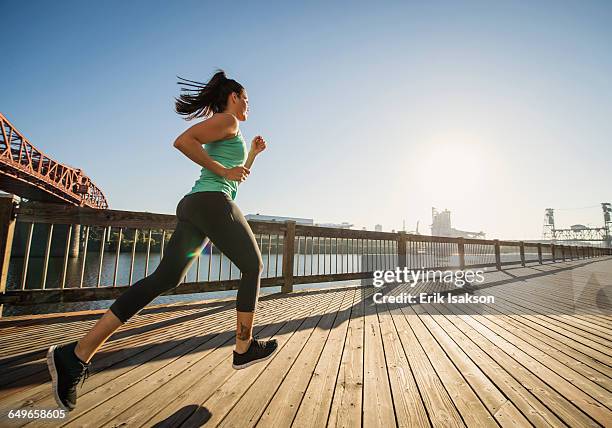 caucasian woman jogging on urban waterfront - ローアングル 女性 ストックフォトと画像