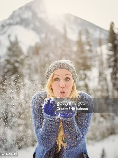 caucasian woman playing in snow - schnee pusten stock-fotos und bilder