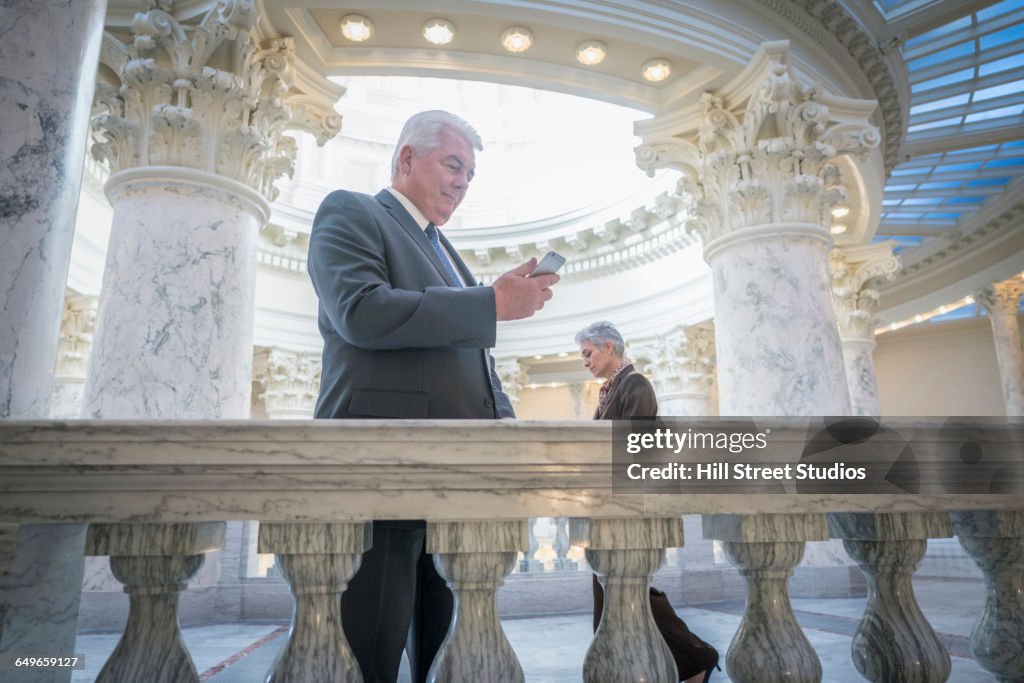 Caucasian senator using cell phone in capitol