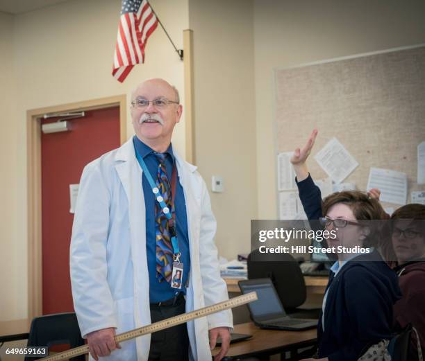 teacher holding yardstick in science classroom - meter stick stock pictures, royalty-free photos & images