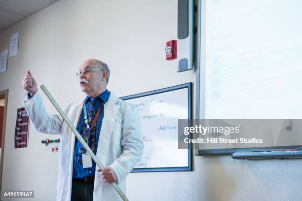 teacher giving lecture in science classroom - meter stick stock pictures, royalty-free photos & images