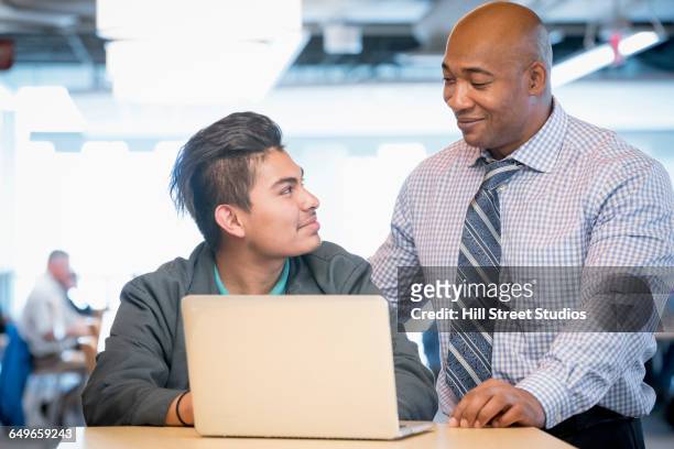 mentor helping student use laptop - african american mentor stock-fotos und bilder