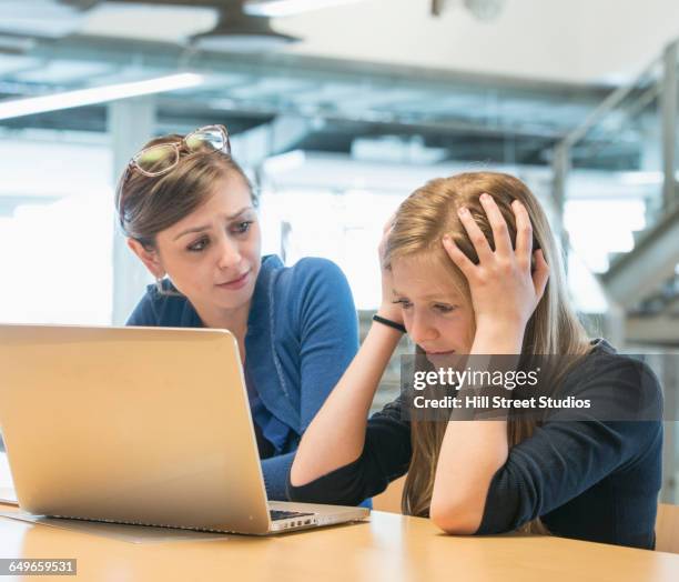 teacher helping student use laptop in library - tensed idaho stock pictures, royalty-free photos & images