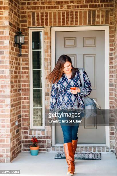 hispanic woman walking on front stoop - people leaving stock pictures, royalty-free photos & images