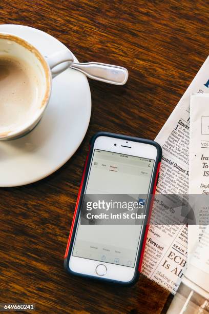 cell phone, newspaper and coffee cup in cafe - coffee and news paper foto e immagini stock