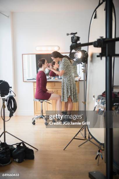 model having makeup applied by stylist - photoshoot bts stock pictures, royalty-free photos & images