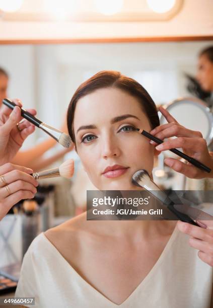 woman having makeup applied by stylists - visagist stockfoto's en -beelden
