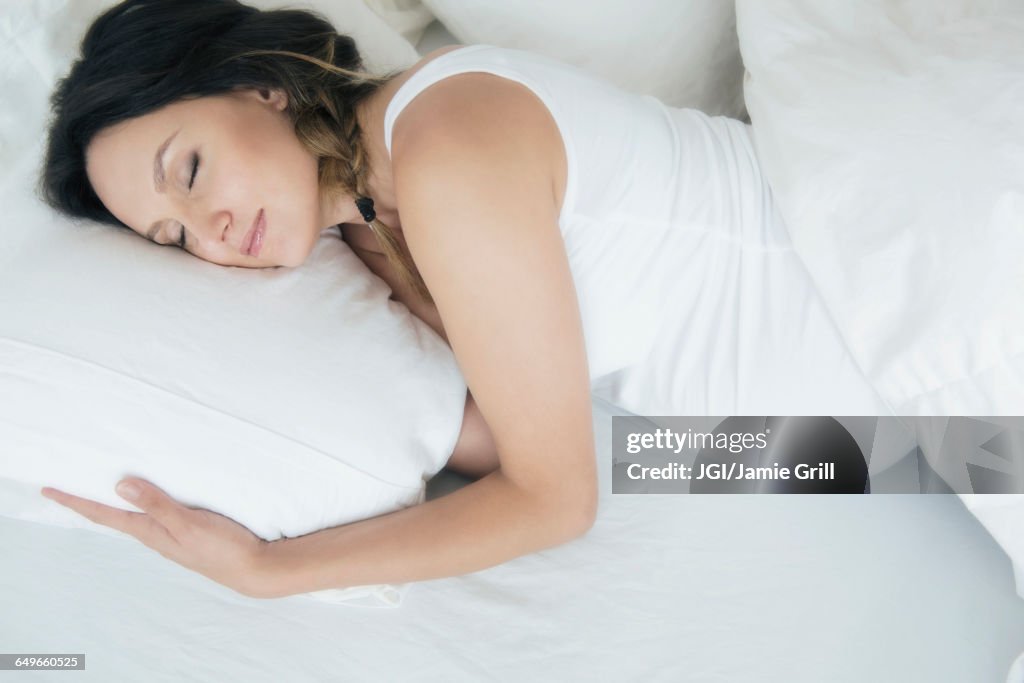 Pregnant Caucasian woman sleeping in bed