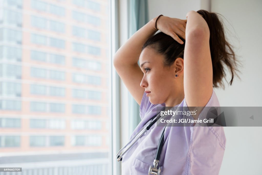 Nurse tying her hair up in hospital