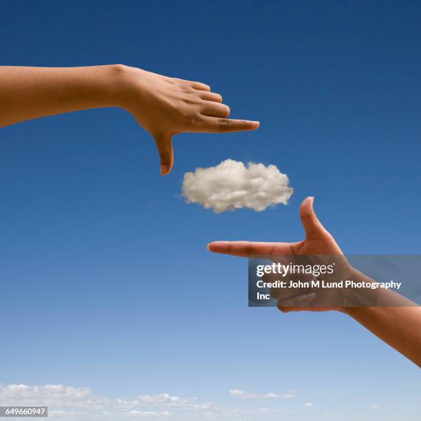 mixed race woman making finger frame around cloud - finger frame stock-fotos und bilder