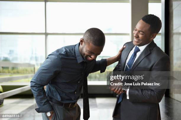 african american businessmen laughing in office - business man laughing stock-fotos und bilder