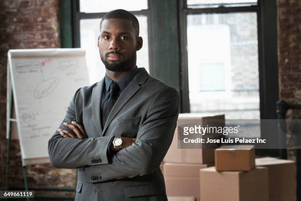 african american businessman standing in new office - business owner suit stock-fotos und bilder