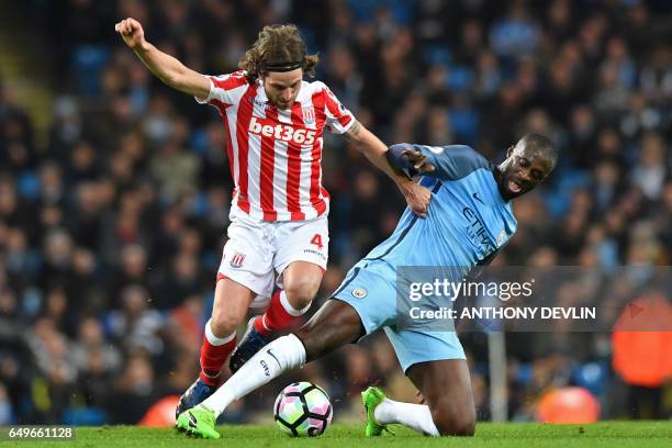 Stoke City's Welsh midfielder Joe Allen vies with Manchester City's Ivorian midfielder Yaya Toure during the English Premier League football match...