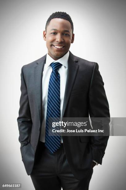 african american businessman smiling with hand in pockets - businessman hands in pockets stock pictures, royalty-free photos & images