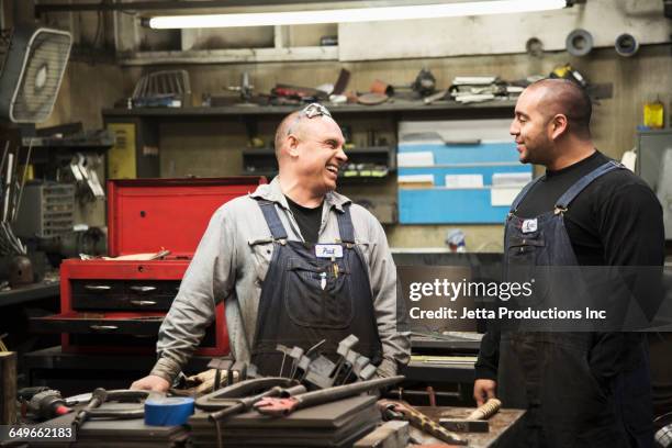 workers talking in workshop - tradesman stock pictures, royalty-free photos & images