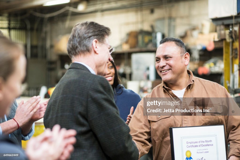 Worker receiving award in workshop