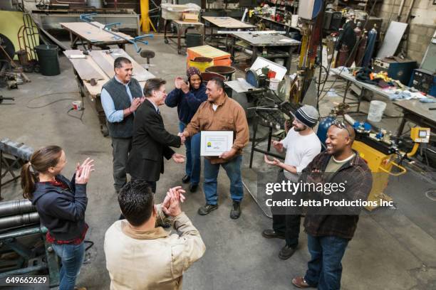 high angle view of worker and businessman shaking hands in workshop - respect awards inside stock-fotos und bilder