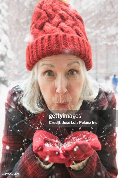 older caucasian woman playing in snow - schnee pusten stock-fotos und bilder