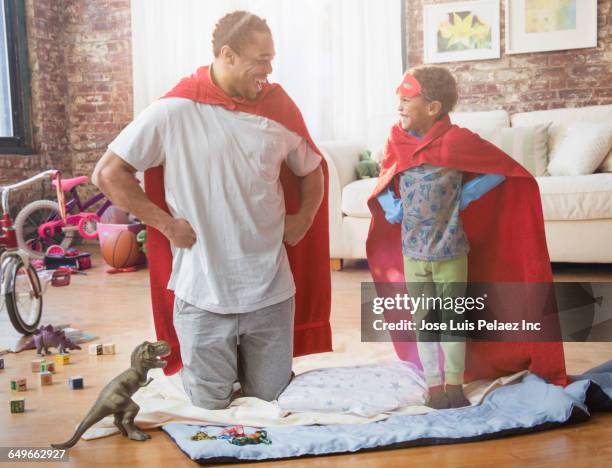 father and son playing dress-up in living room - zwarte mantel stockfoto's en -beelden