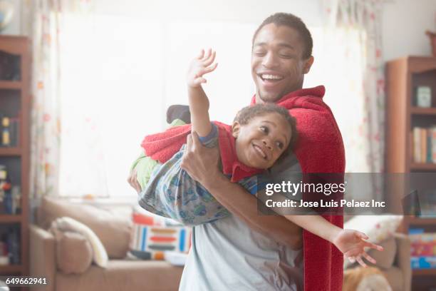 father and son playing dress-up in living room - hero stock pictures, royalty-free photos & images