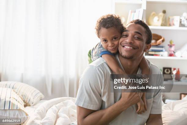 father and son hugging on bed - two boys in bed stock pictures, royalty-free photos & images