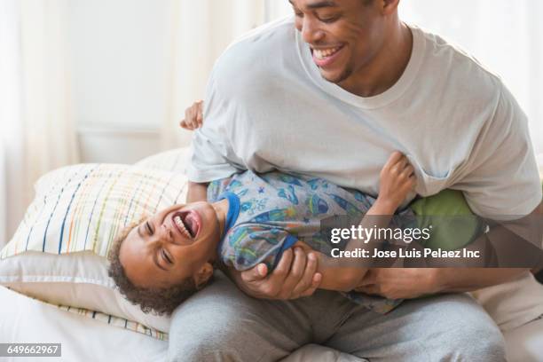 father and son playing in bedroom - tickling 個照片及圖片檔