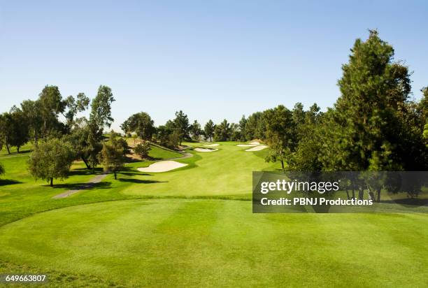 high angle view of golf course under blue sky - parcours photos et images de collection