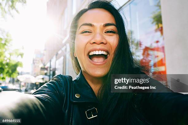 asian woman smiling outdoors - woman selfie stockfoto's en -beelden