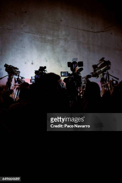 silhouette of reporters and video cameras at press conference - video conference stock-fotos und bilder