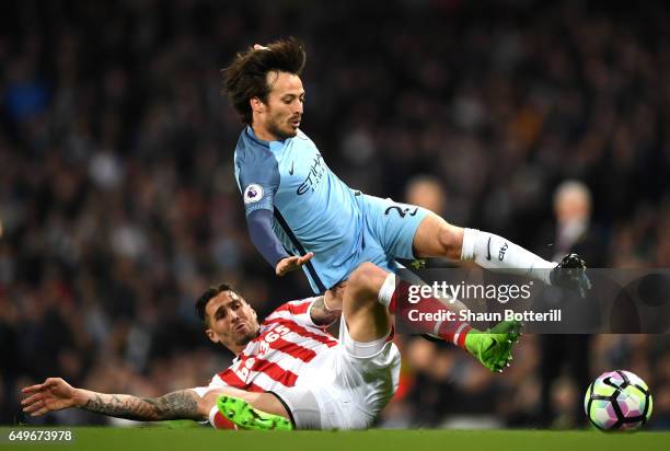 Geoff Cameron of Stoke City tackles David Silva of Manchester City during the Premier League match between Manchester City and Stoke City at Etihad...