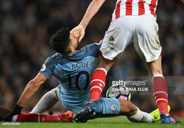 Manchester City's Argentinian striker Sergio Aguero gets a hand in the face from Stoke City's English defender Ryan Shawcross during the English...