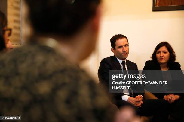 French presidential election candidate for the left-wing French Socialist party Benoit Hamon talks with women during a visit to a shelter for abused...