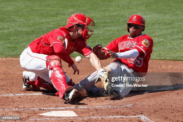 Ben Revere of the Los Angeles Angels slides into home as Rob Brantly of the Cincinnati Reds cannot field the throw in the second inning during the...