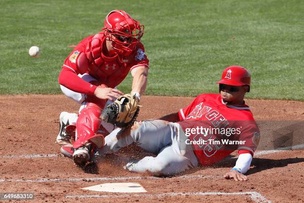 Ben Revere of the Los Angeles Angels slides into home as Rob Brantly of the Cincinnati Reds cannot field the throw in the second inning during the...