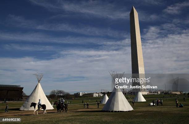 Tepees set up by Dakota Access Pipeline protesters stand next to the Washington Monument on March 8, 2017 in Washington, DC. Indigenous rights...